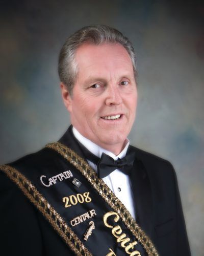 A man in a tuxedo is wearing a sash that says centaur 2008