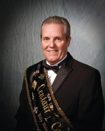 A man in a tuxedo is wearing a sash that says louisiana