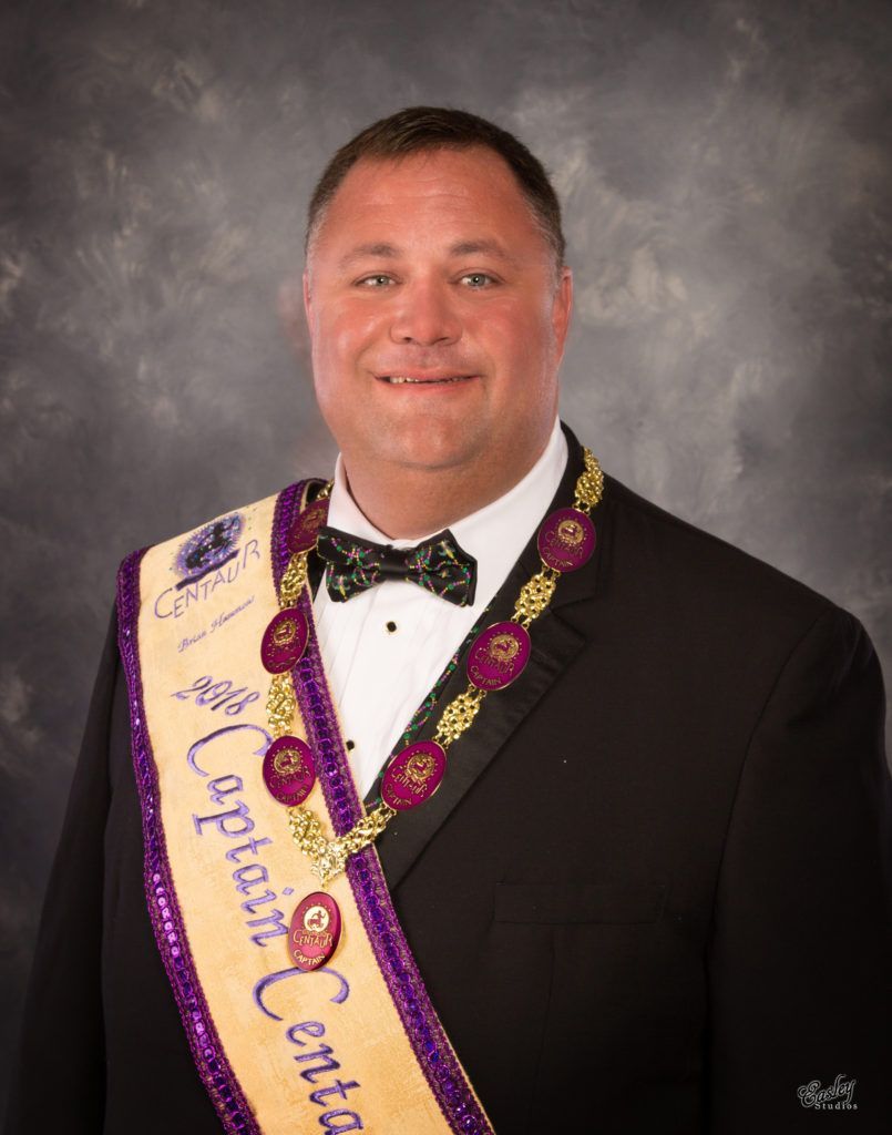 A man in a suit and bow tie is wearing a sash that says opposition central.