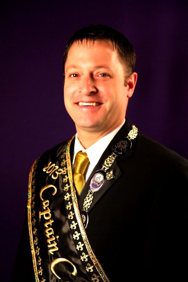A man wearing a sash that says captain on it