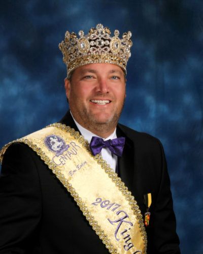 A man wearing a crown and a sash that says 2017 king