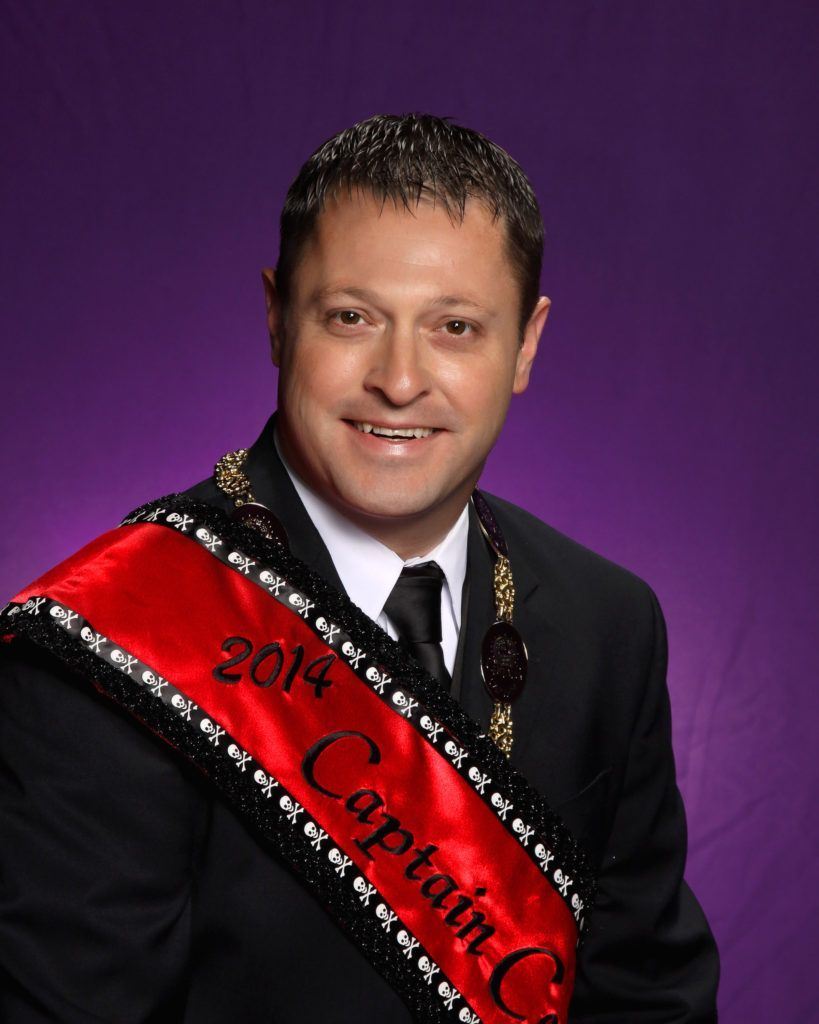 A man wearing a sash that says 2014 captain c.
