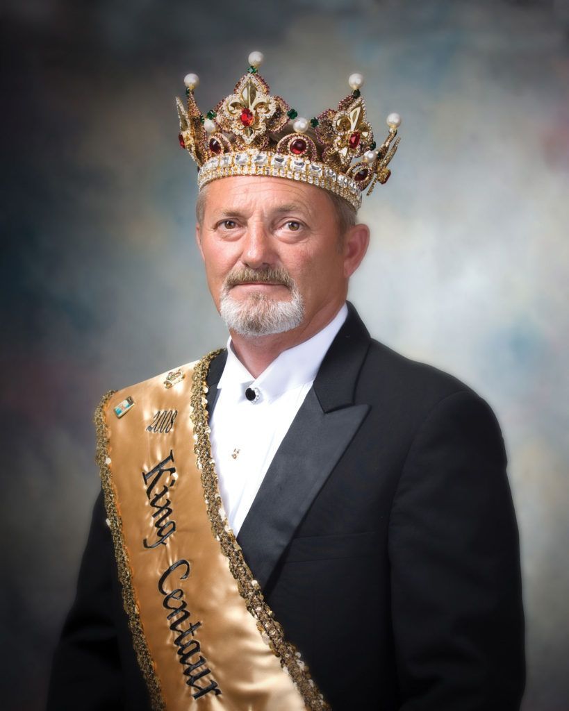 A man wearing a crown and a sash that says ' king ' on it