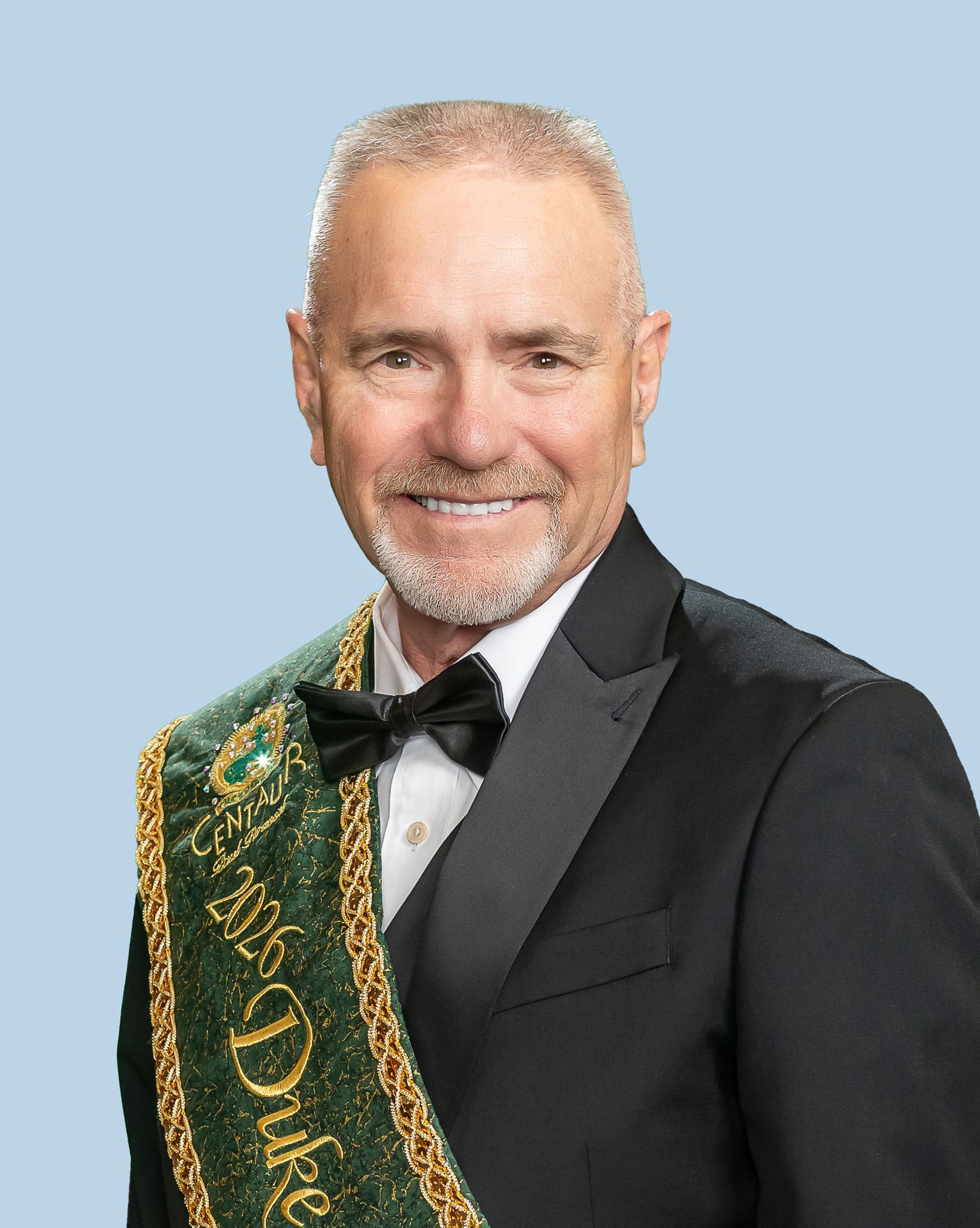 A man is wearing a sash that says duke of