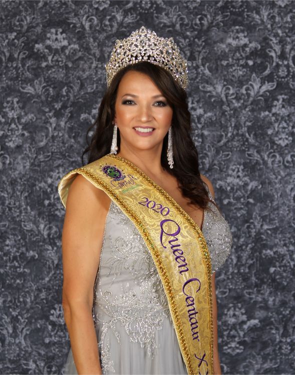 A woman wearing a tiara and a sash that says queen catalina