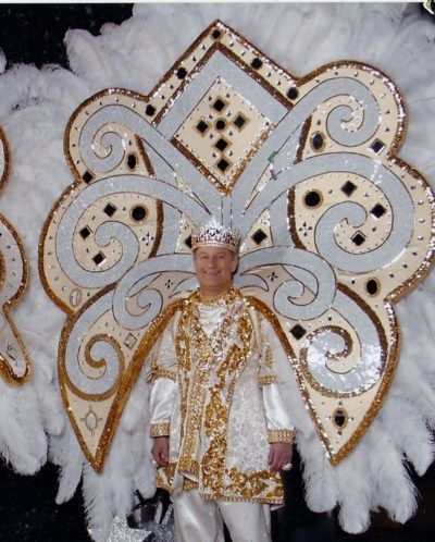 A man in a white and gold costume with feathers