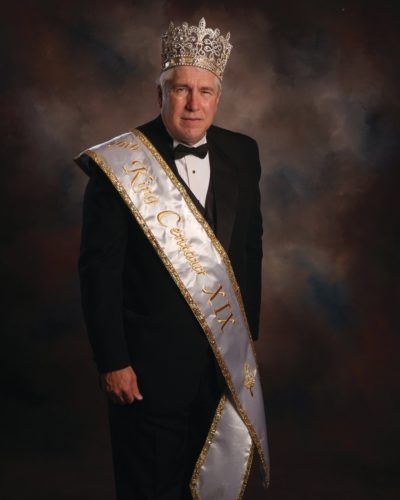A man is wearing a crown and a sash that says miss california