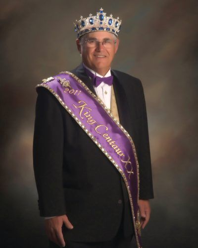 A man wearing a crown and a sash that says king centurion