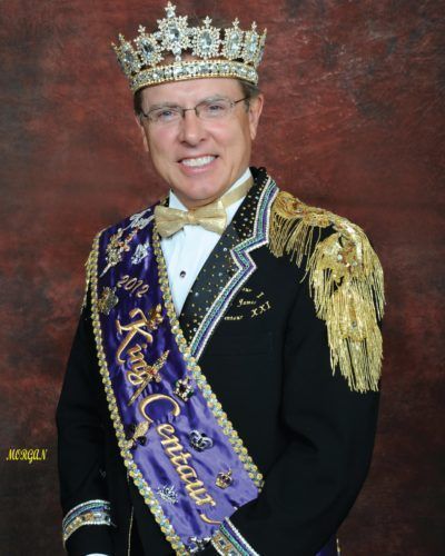 A man wearing a crown and a sash that says ' king ' on it