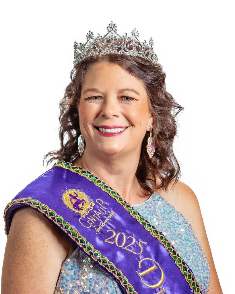 A woman wearing a tiara and a sash is smiling.