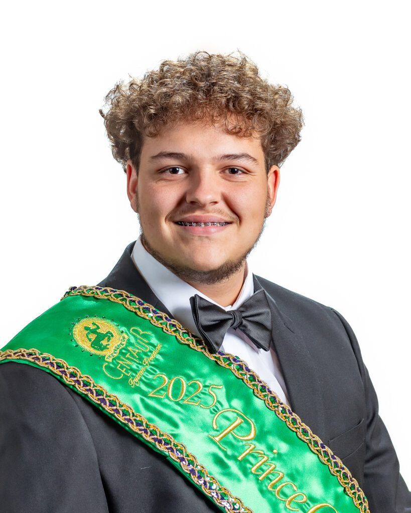 A man in a suit and bow tie is wearing a green sash that says prince