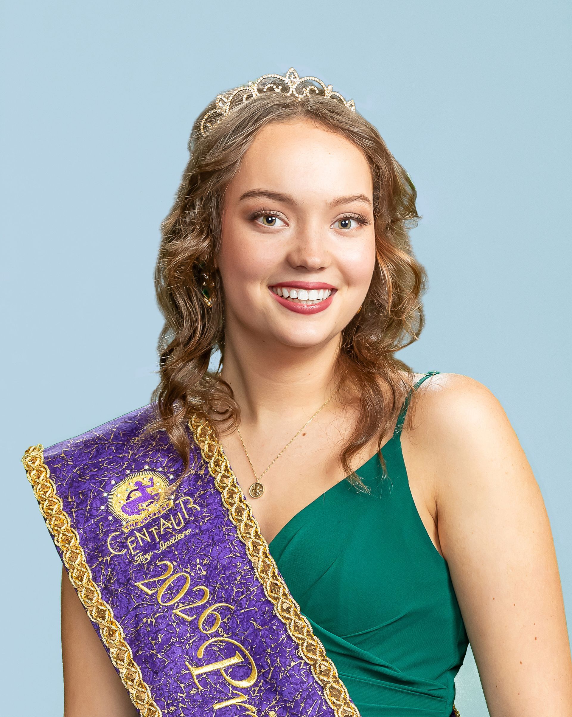 A woman wearing a purple sash and a tiara who is a princess. 
