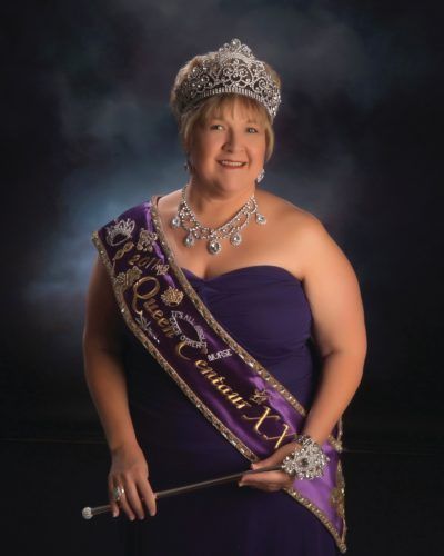 A woman wearing a sash that says queen centuri x
