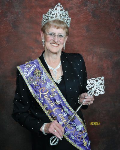 A woman wearing a sash that says queen on it