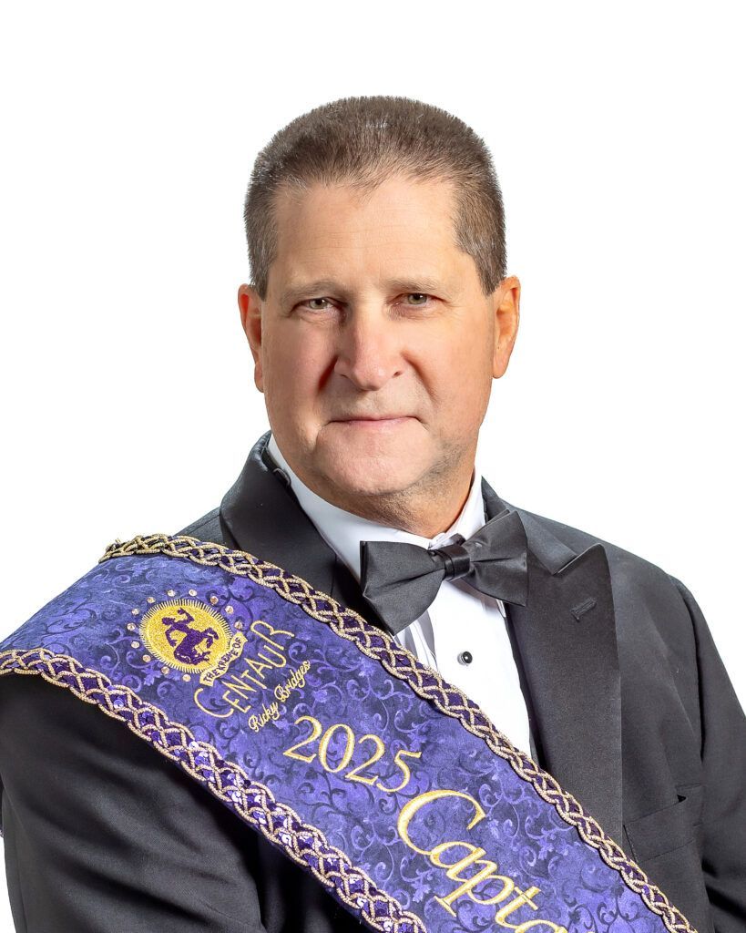 A man in a tuxedo is wearing a sash with the year 2025 on it.