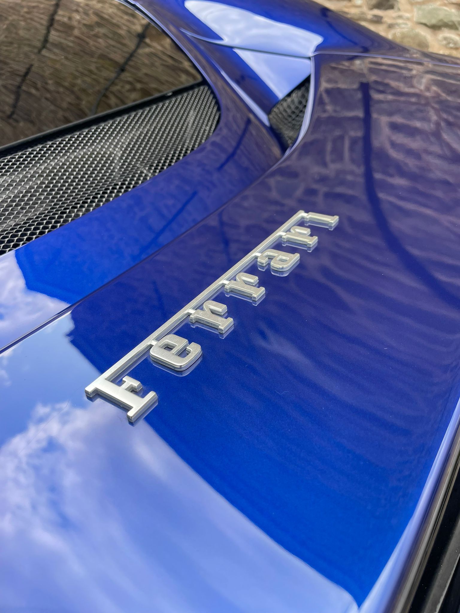 Blue Ferrari emblem on the rear of a sports car.