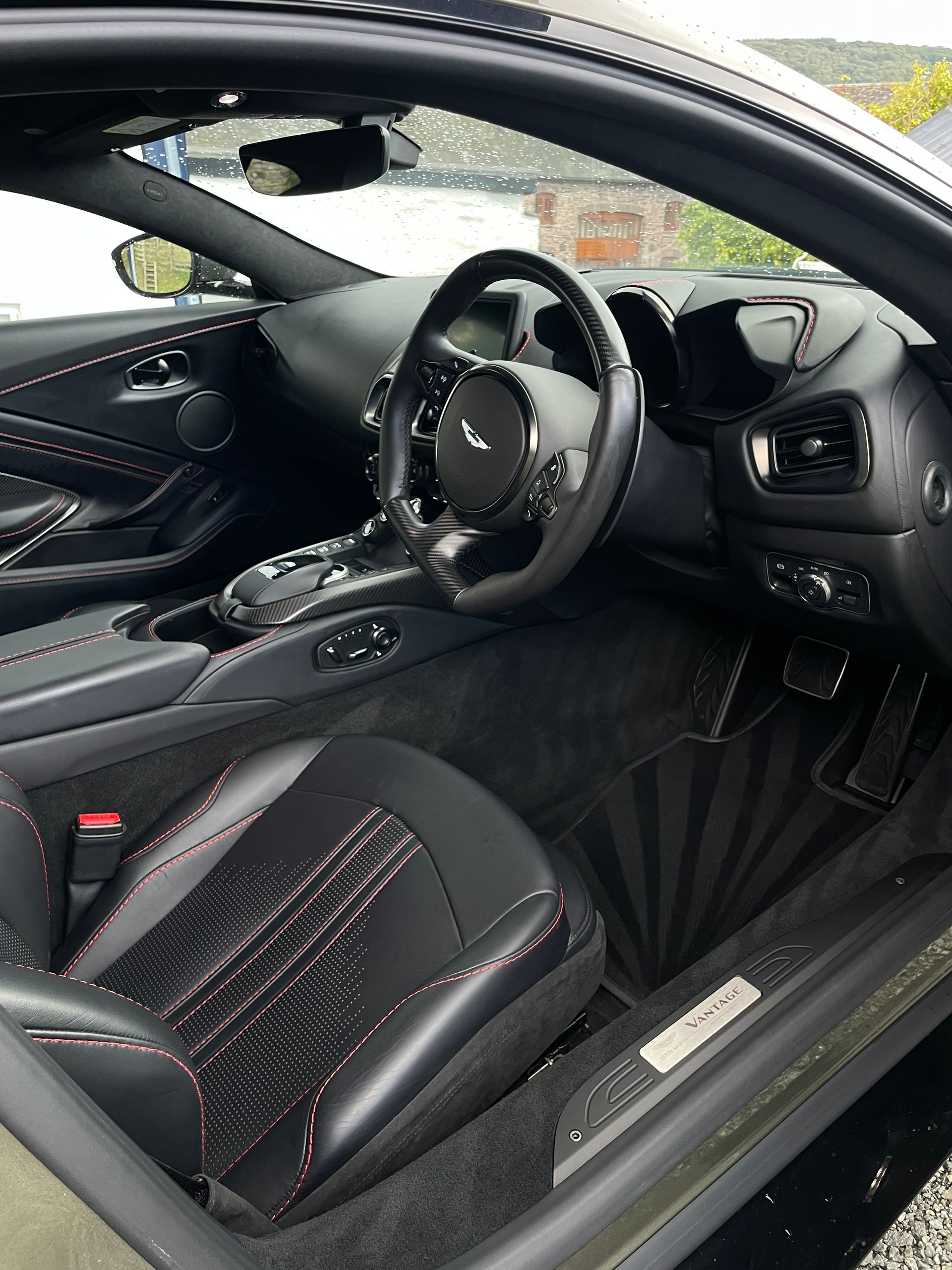 Interior view of a sleek, black luxury sports car with leather bucket seats and a steering wheel on the right side.