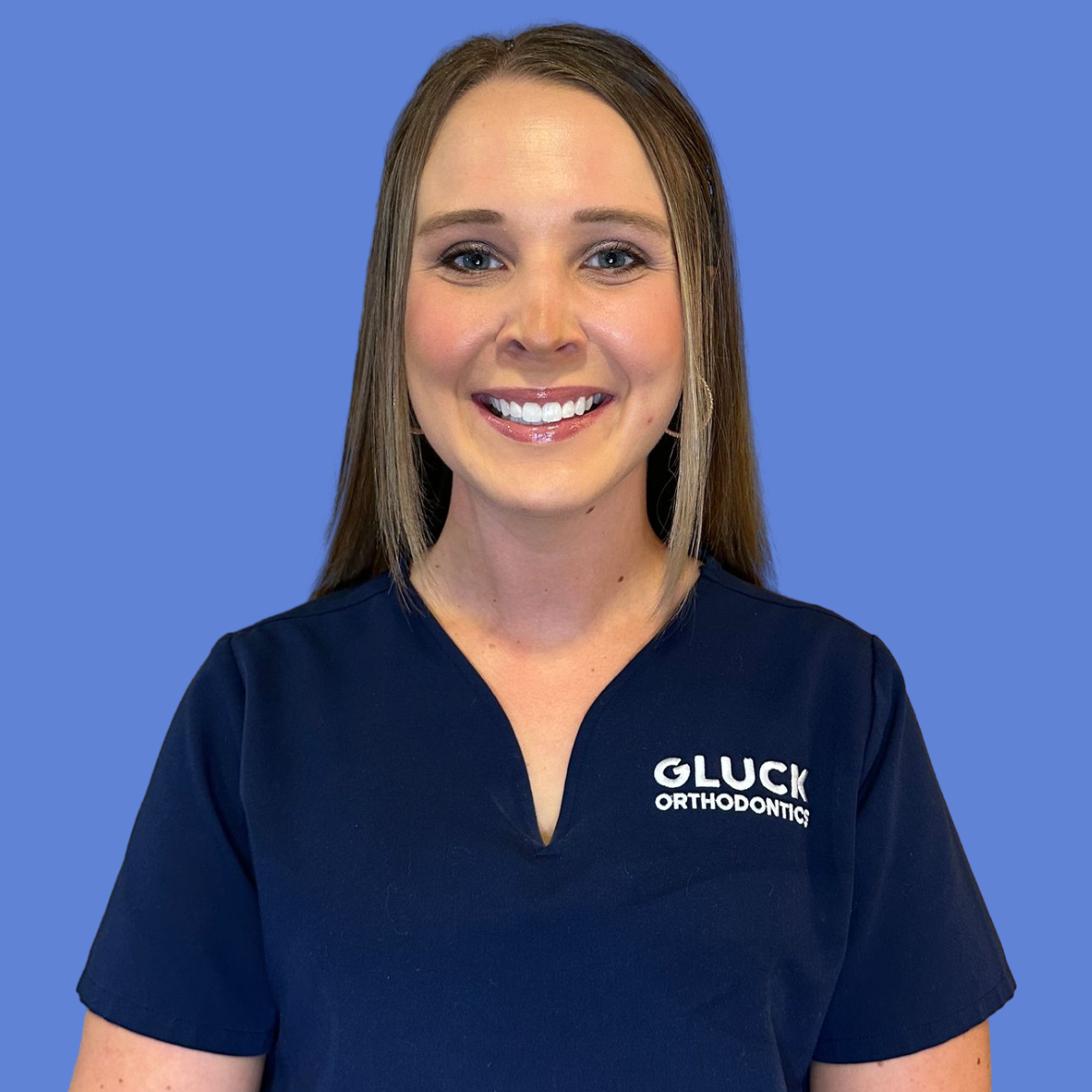 A woman wearing a black scrub top with the name summer on it