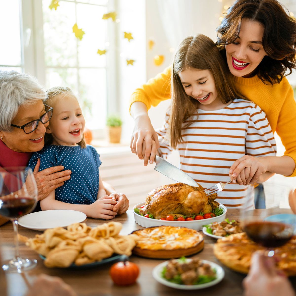 A family is sitting at a table eating a turkey.