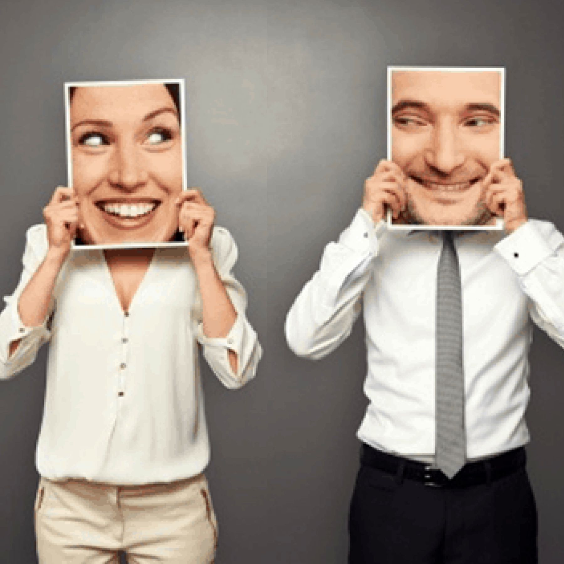 A man and a woman are holding pictures of their faces in front of their faces