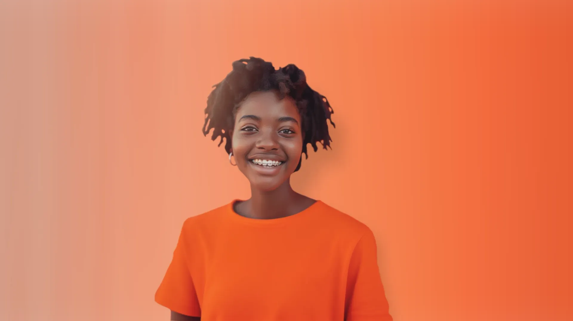 A young woman in an orange shirt is smiling in front of an orange background.