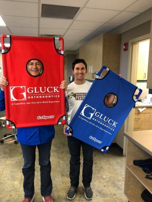 Two men holding a red and blue gluck bag