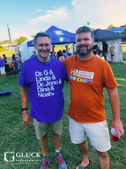 Two men standing next to each other wearing shirts that say dr. g & linda & dr. jono & dina & noah