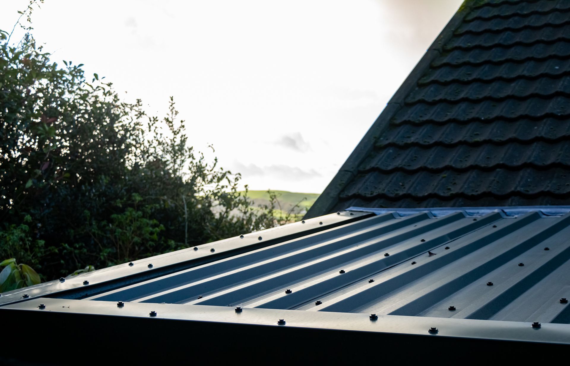 Metal roofing services in progress, showing secured metal roof panels on a residential structure. 
