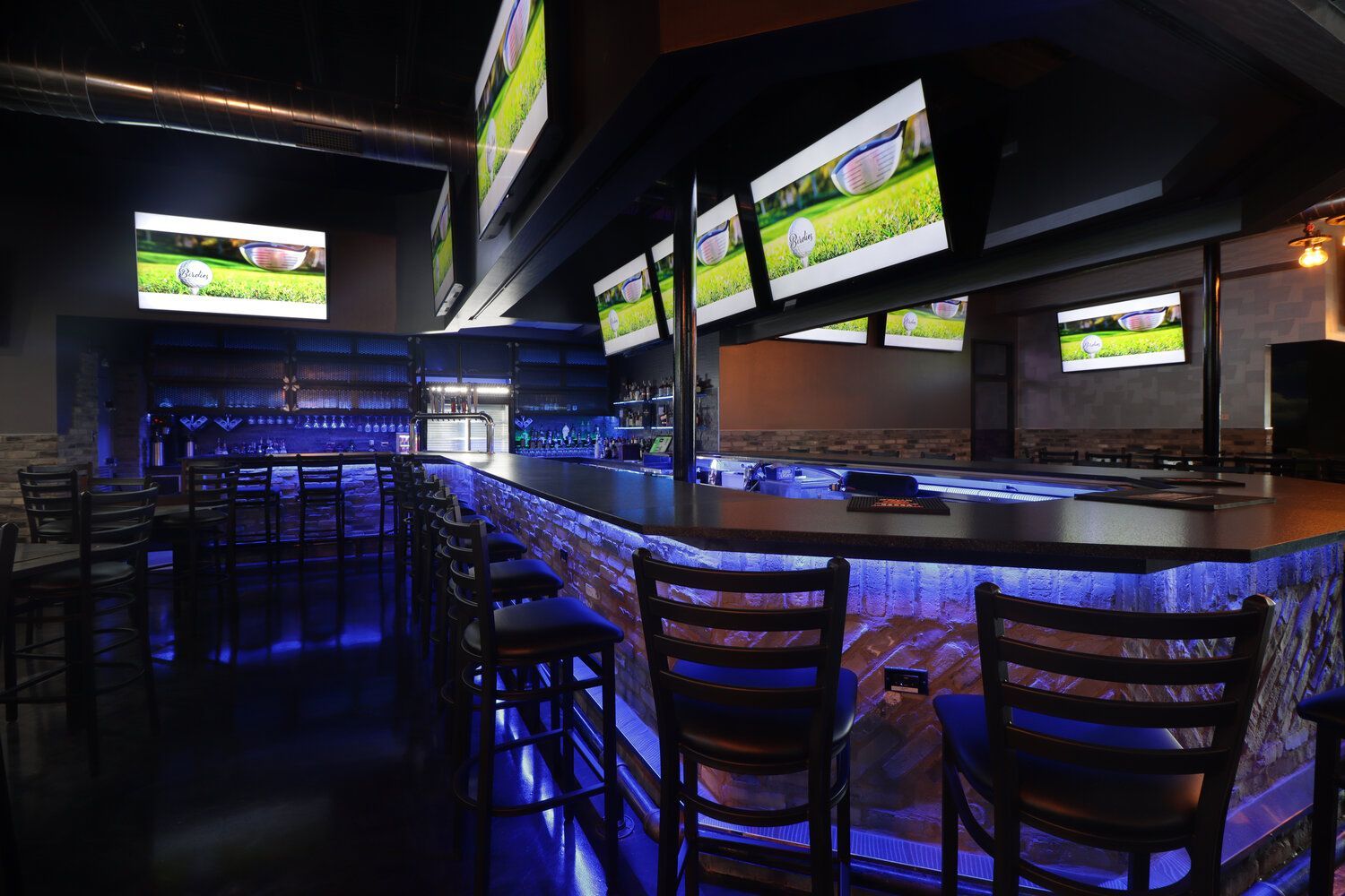 A bar with a lot of televisions on it