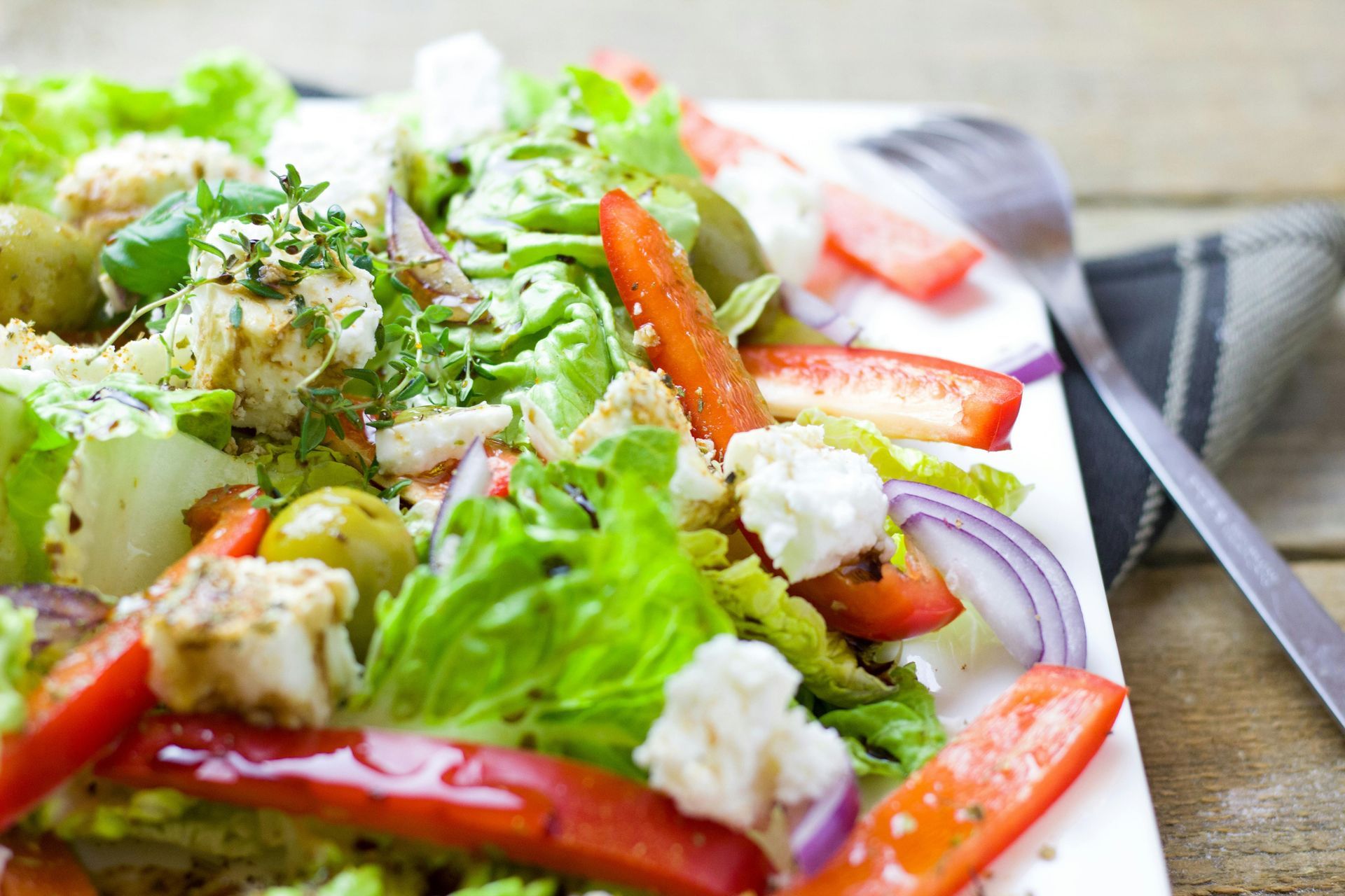 A close up of a salad on a plate with a fork.