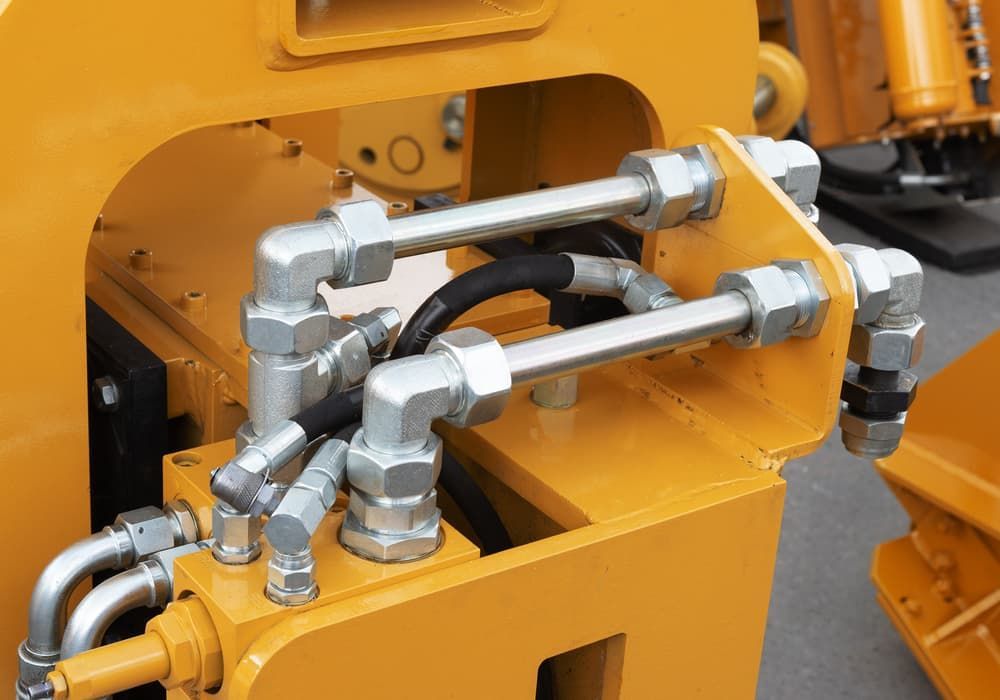 A Close Up of a Hydraulic System on a Yellow Machine — FNQ Filters & Parts In Mareeba, QLD