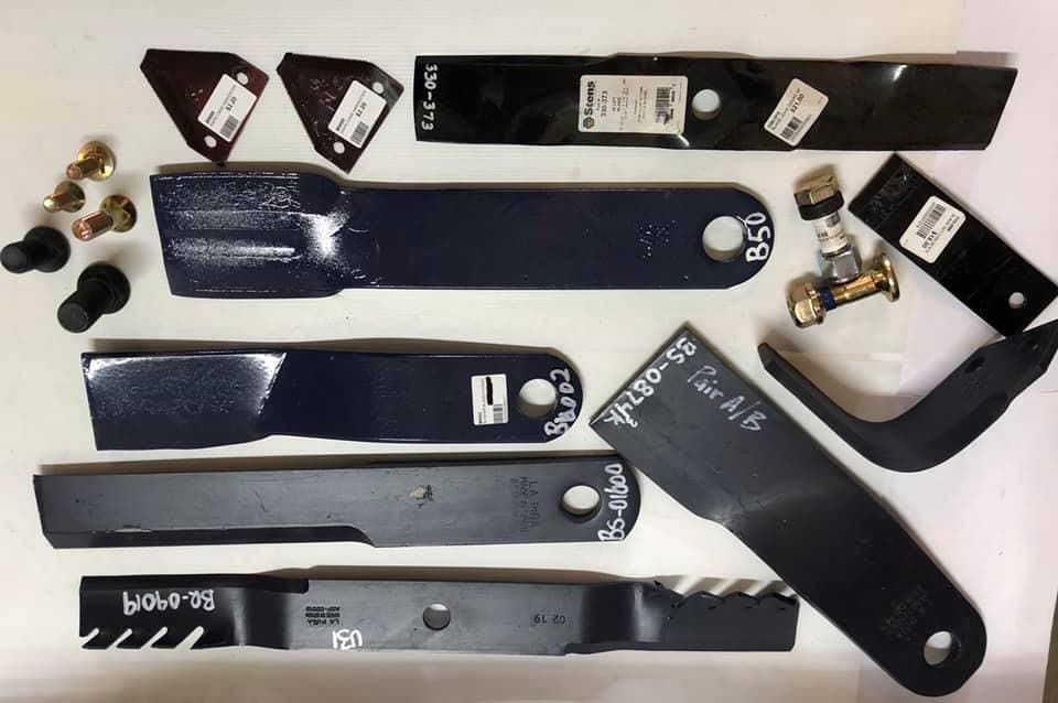 A Bunch of Lawn Mower Blades on a White Surface — FNQ Filters & Parts In Mareeba, QLD