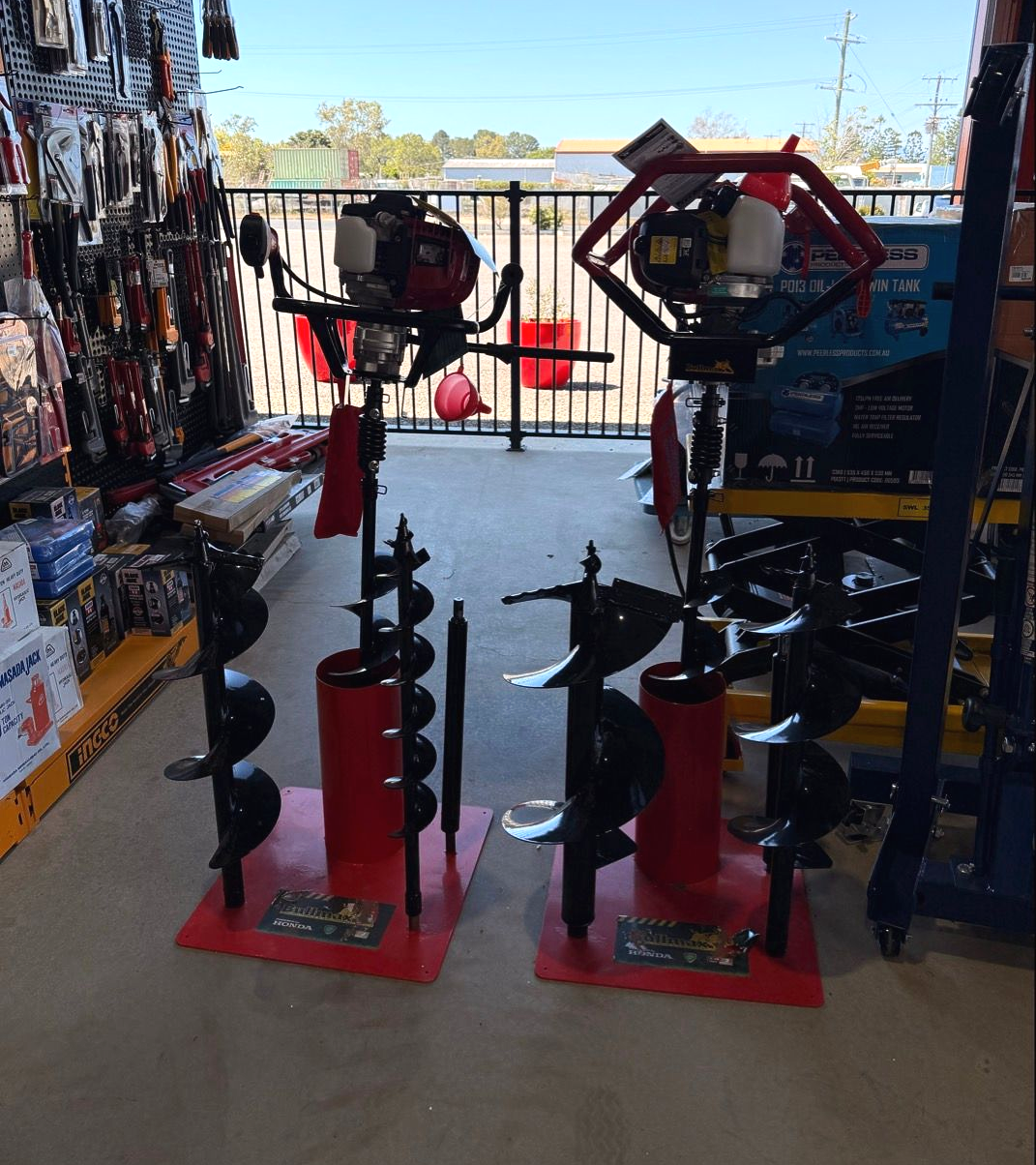 A Person Operating a Gas-powered Auger on a Grassy Field — FNQ Filters & Parts In Mareeba, QLD