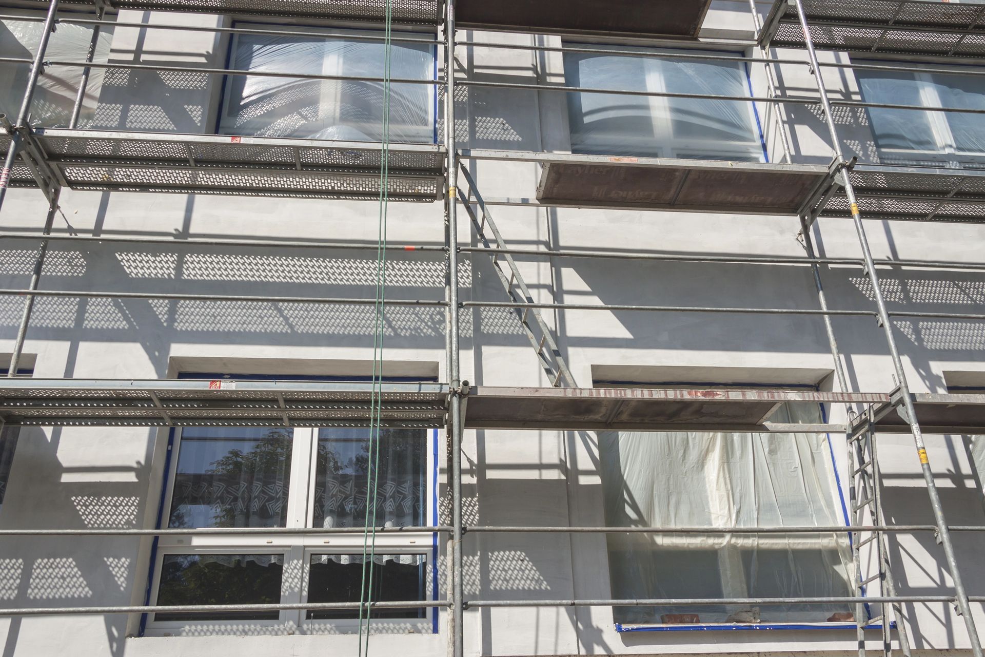 Esterno dell'edificio in fase di ristrutturazione con impalcature attorno alle finestre.