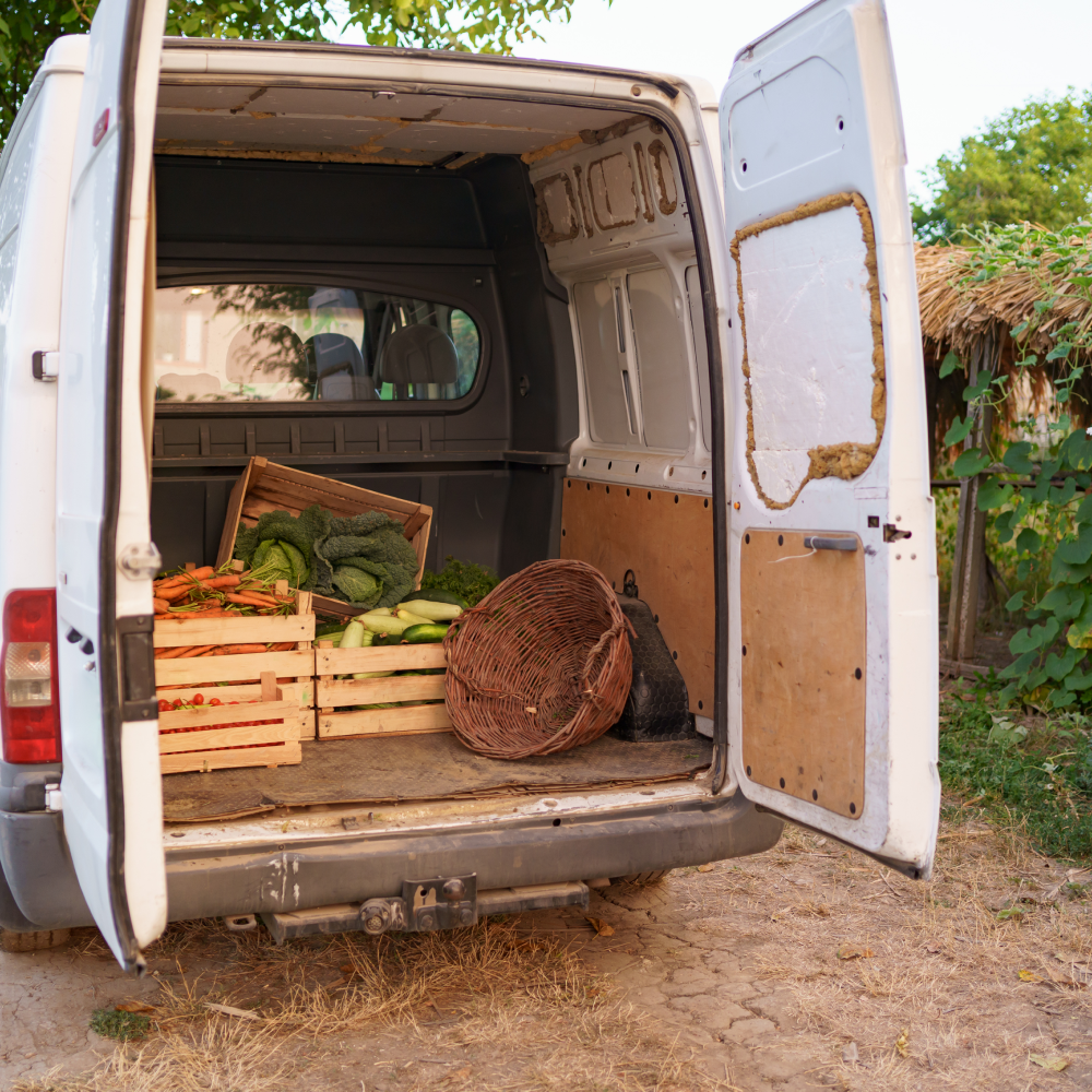 The back of a white van filled with crates of vegetables