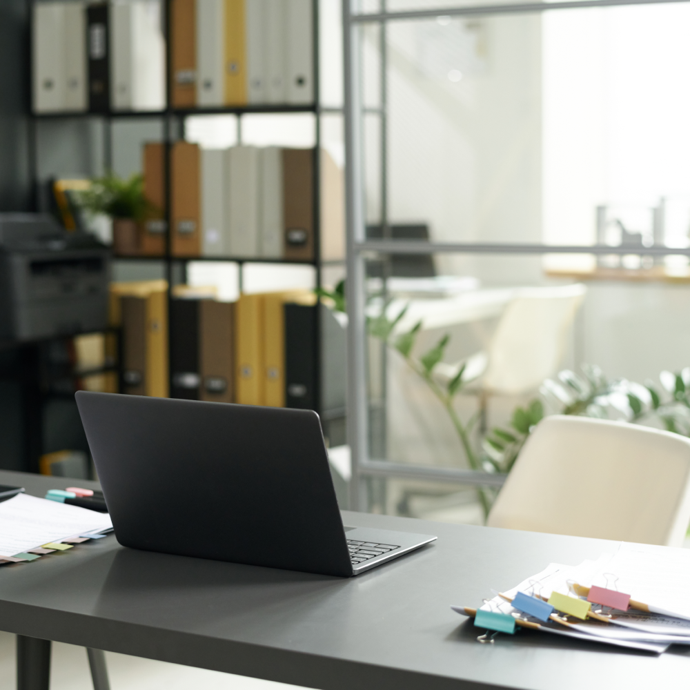 A laptop is open on a desk in an office