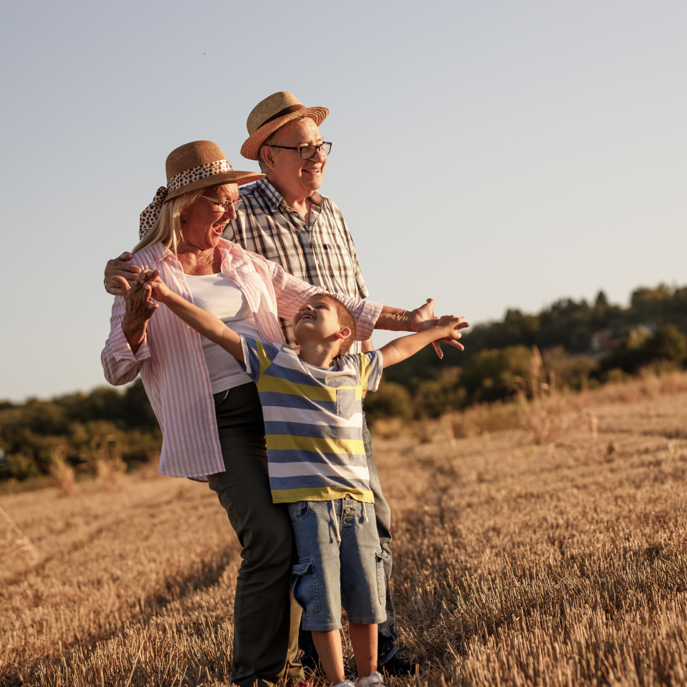 A family standing in a field with their arms outstretched