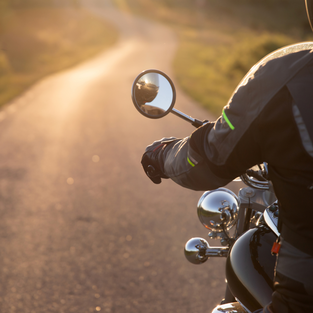 A person is riding a motorcycle down a road