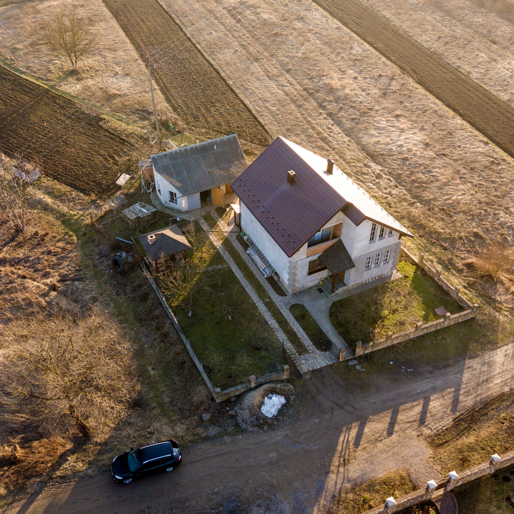 An aerial view of a house in the middle of a field