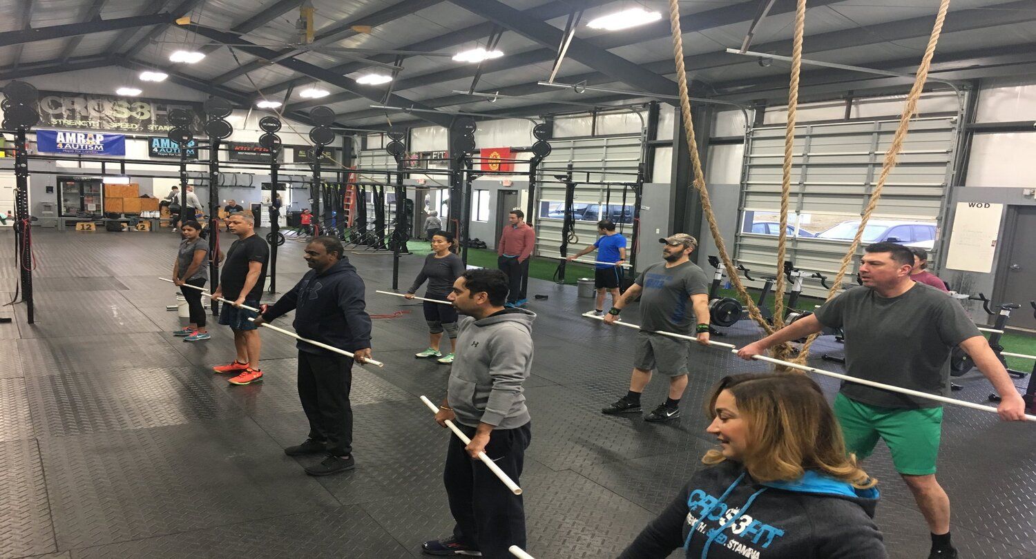 A group of people learning CrossFit movements