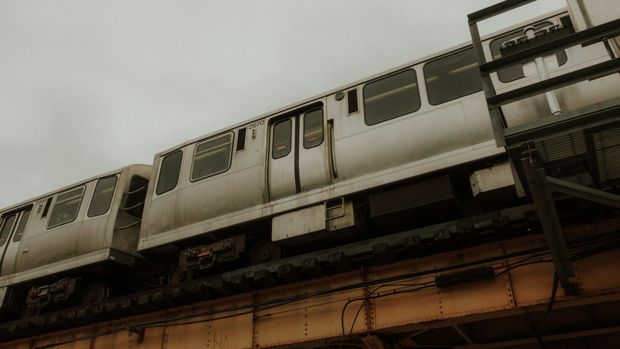 A train is going over a bridge on a cloudy day.