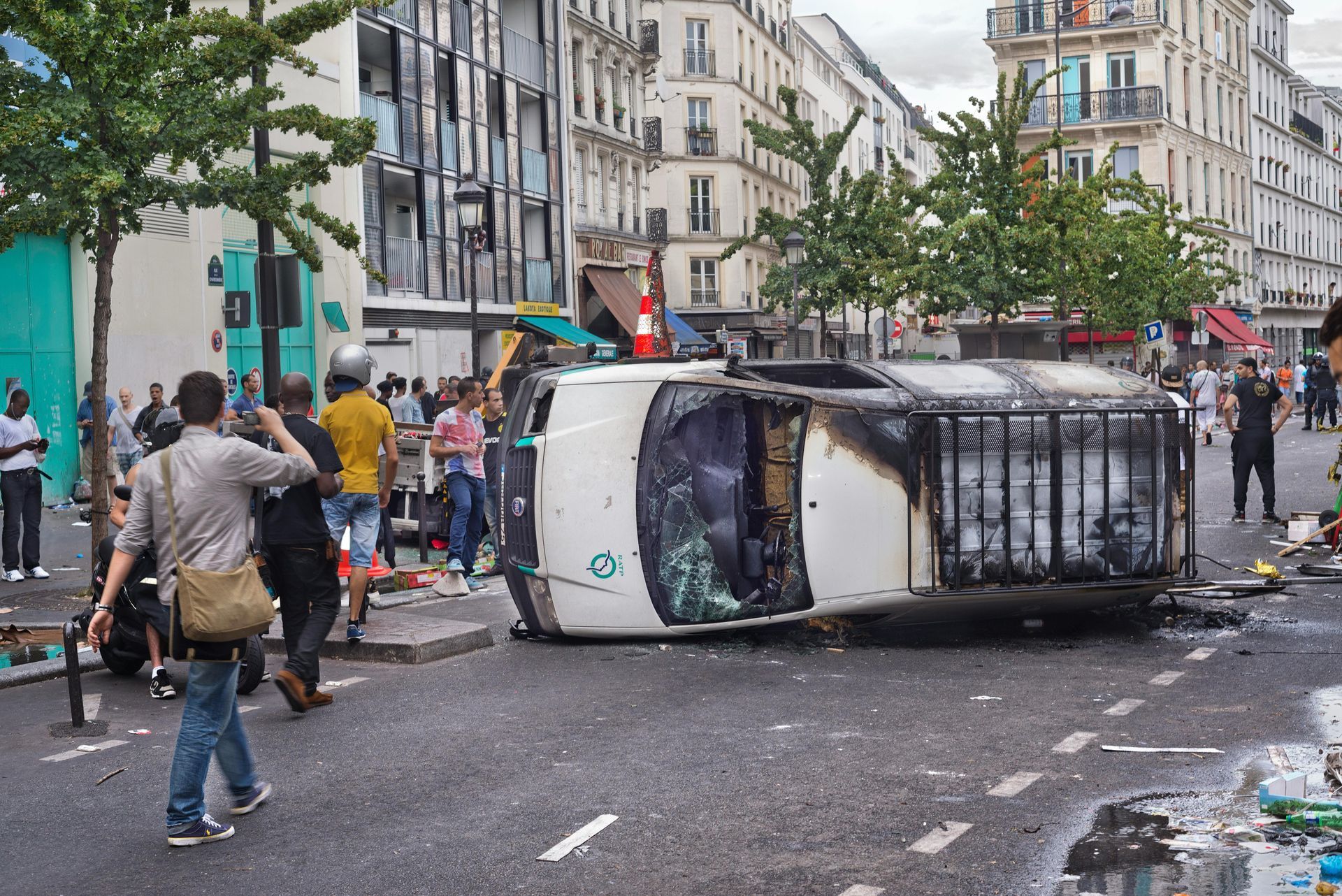 A car is on its side in the middle of a street.