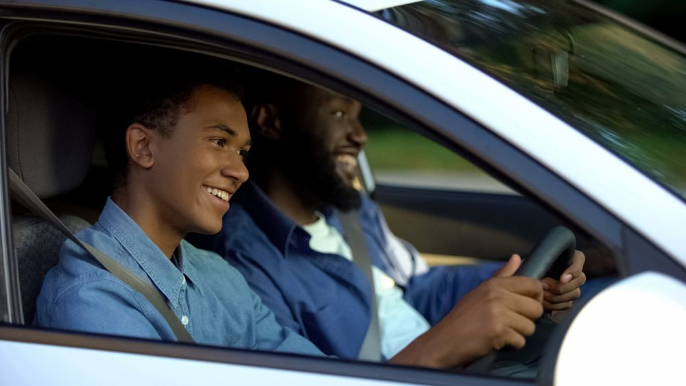 Man and Teenage Boy Smiling in Car, Boy at Wheel — Fulgi's South Coast Automotive and Dismantling in Ulladulla, NSW