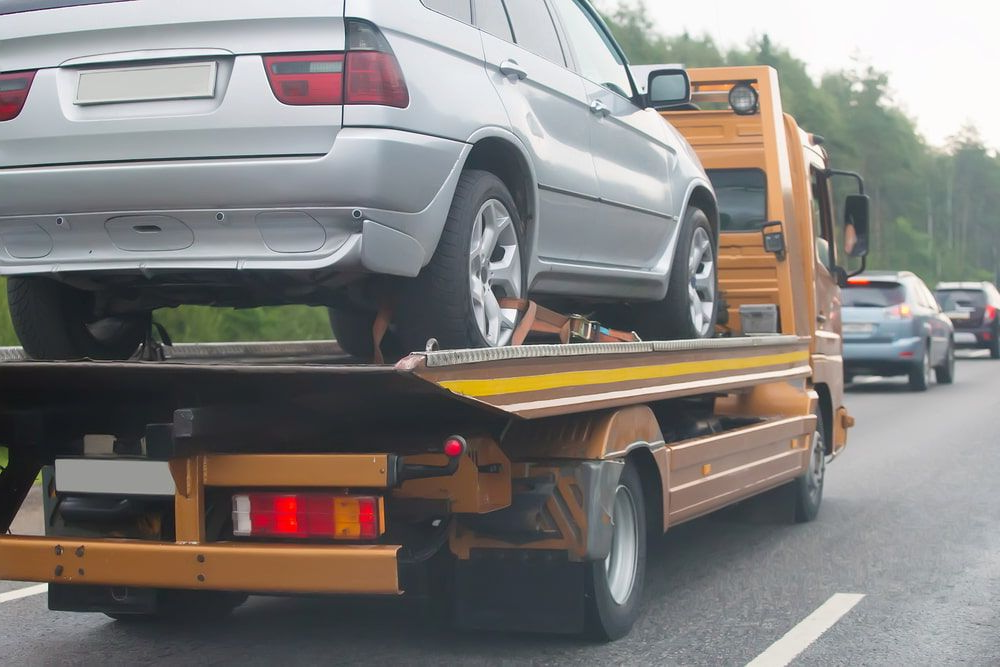 A Silver SUV Being Towed on a Flatbed Tow Truck — Fulgi's South Coast Automotive and Dismantling in South Nowra, NSW