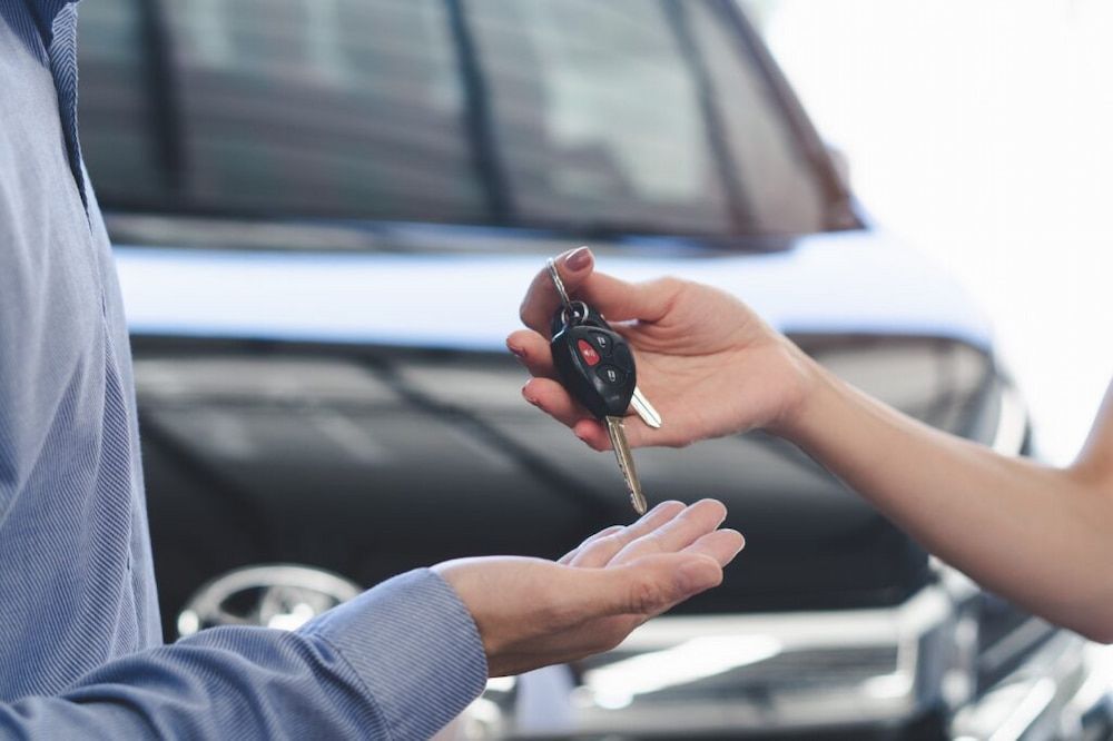 Person Receiving Car Keys in Front of a New Vehicle — Fulgi's South Coast Automotive and Dismantling in Kiama, NSW