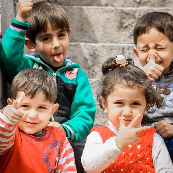 A group of children are giving a thumbs up sign