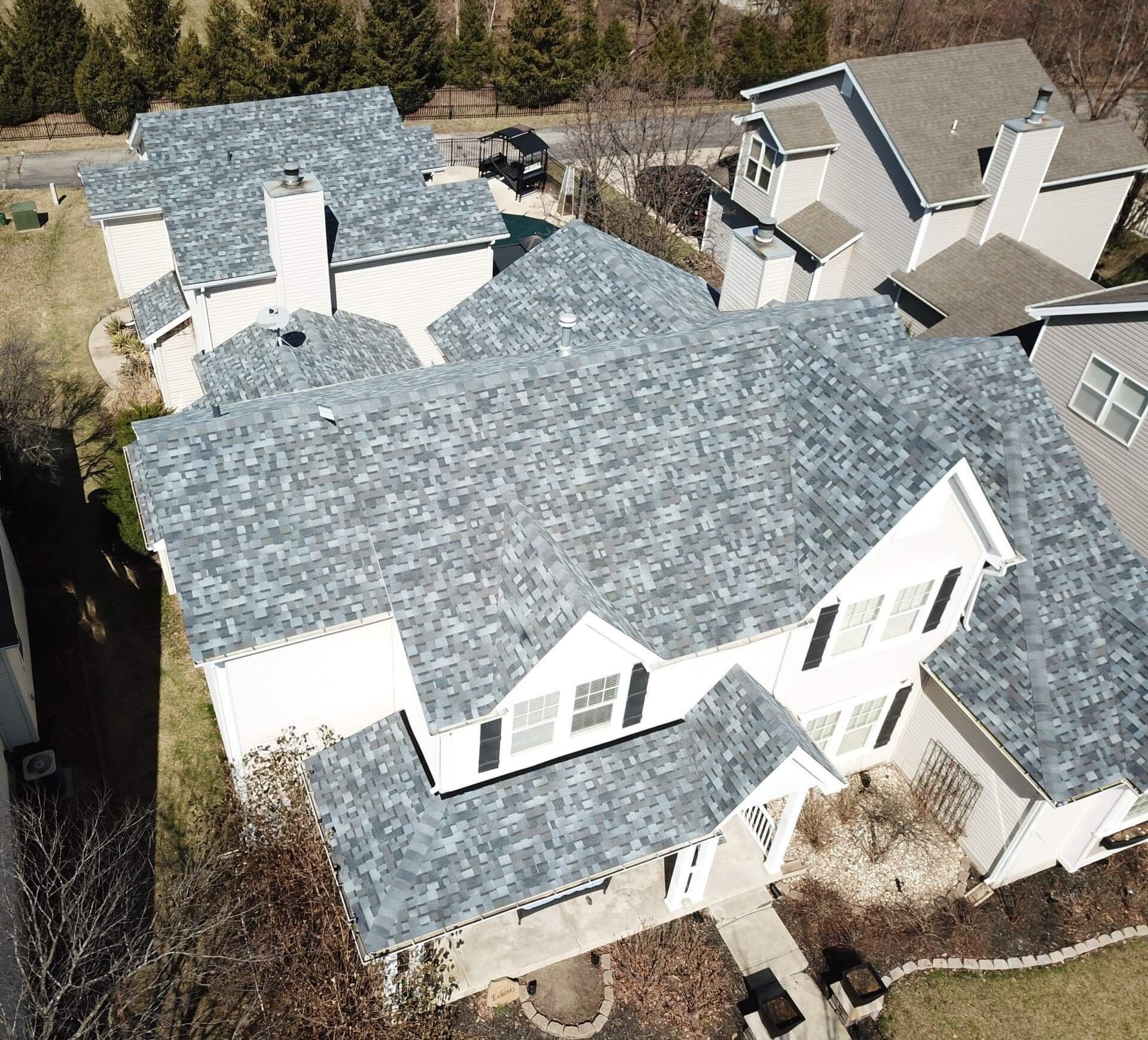 An aerial view of a large white house with a blue roof.