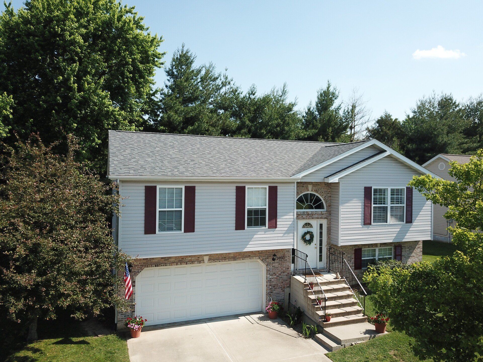 An aerial view of a white house with red shutters