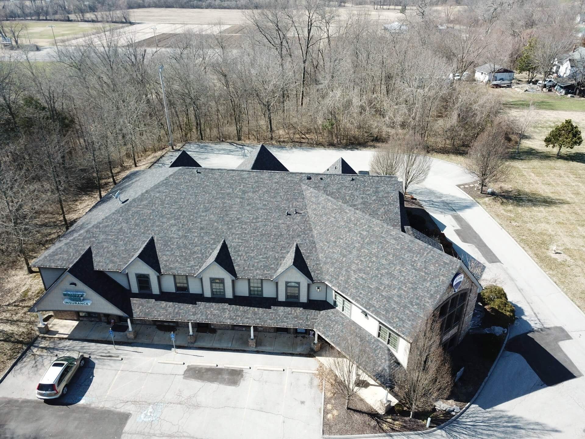 An aerial view of a large house with a black roof