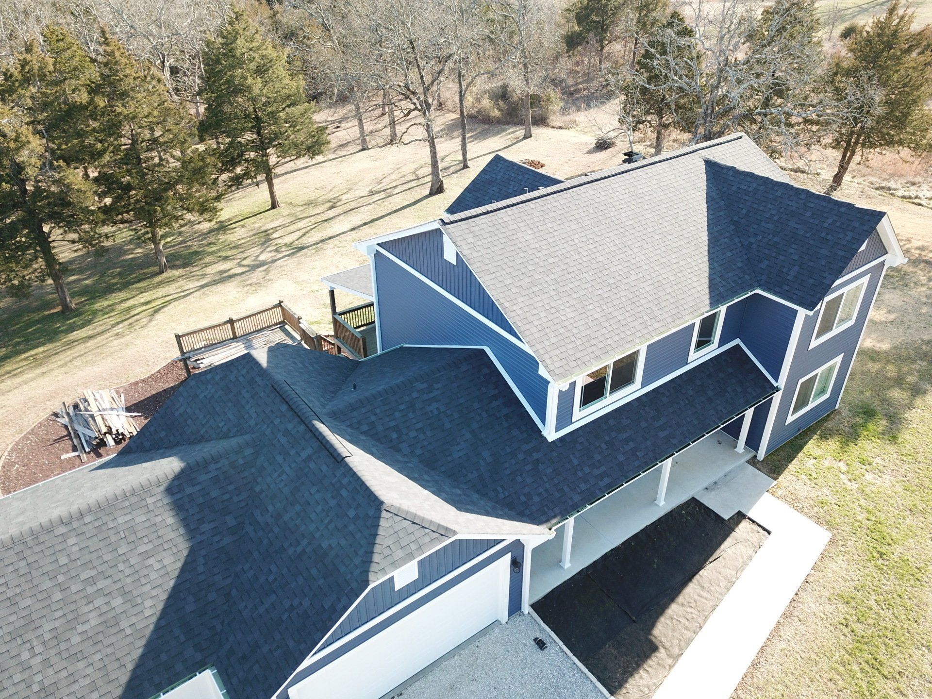 An aerial view of a blue house with a gray roof
